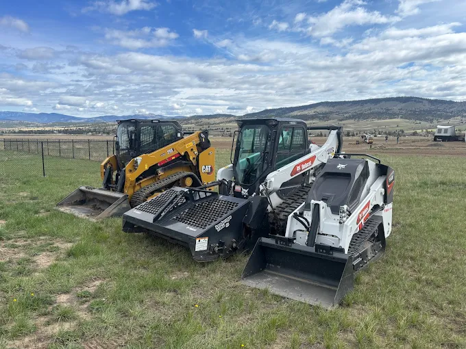 CAT and Bobcat equipment lineup with Montana mountains